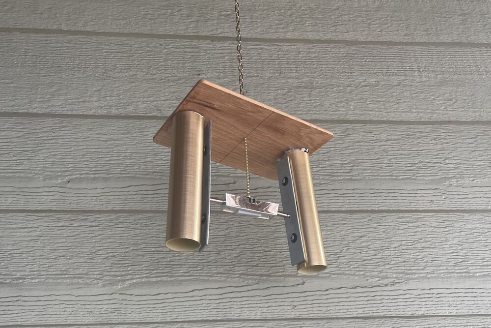 The chime hanging against the siding, seen from further back