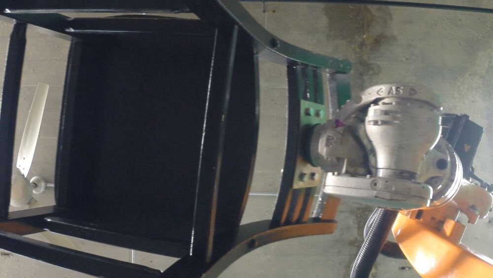 From above, the chair tipped on its side in the arm's grip