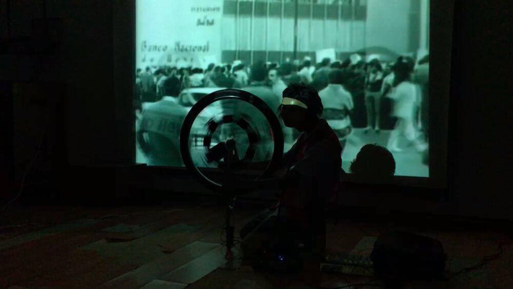 The wheel in silhouette in front of a projected film
