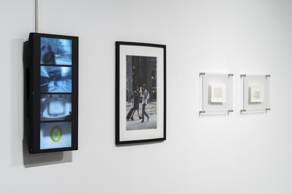 The video documentation on a vertical screen, beside the photograph