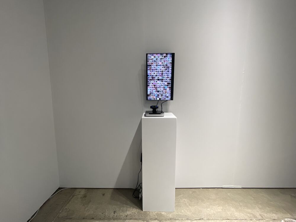 The monitor and plinth in a corner of white walls