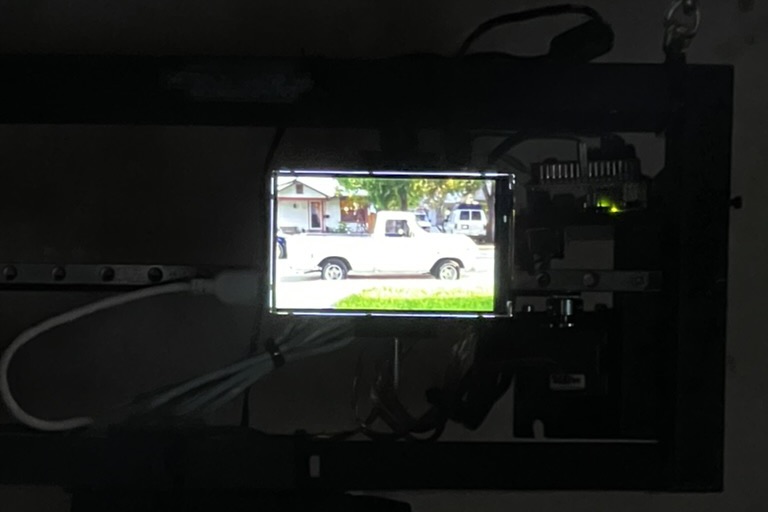 Close up in the dark, the screen showing a white pickup truck parked on a residential street